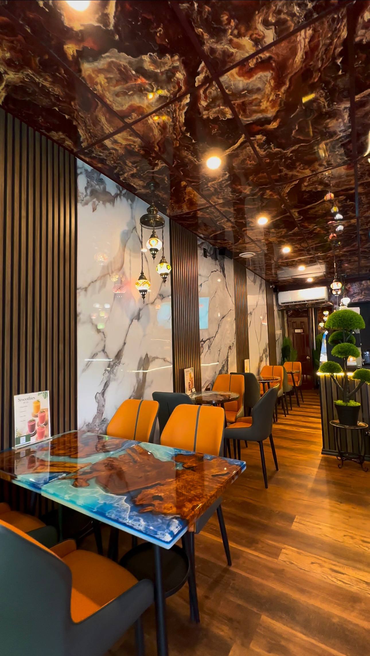 Coffeeccino seating area with warm orange chairs and handcrafted tables